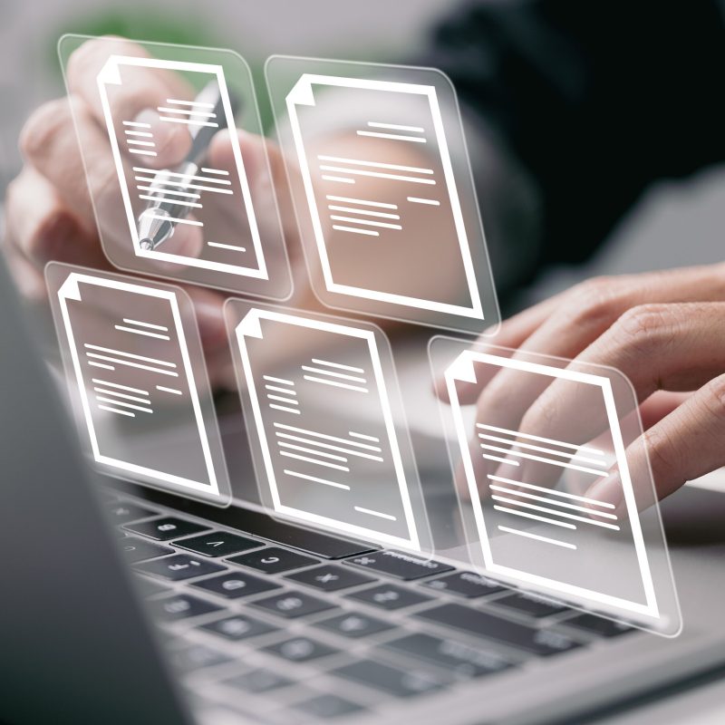 Businessman working on laptop computer with electronics document icons, E-document management, online documentation database, paperless office concept
