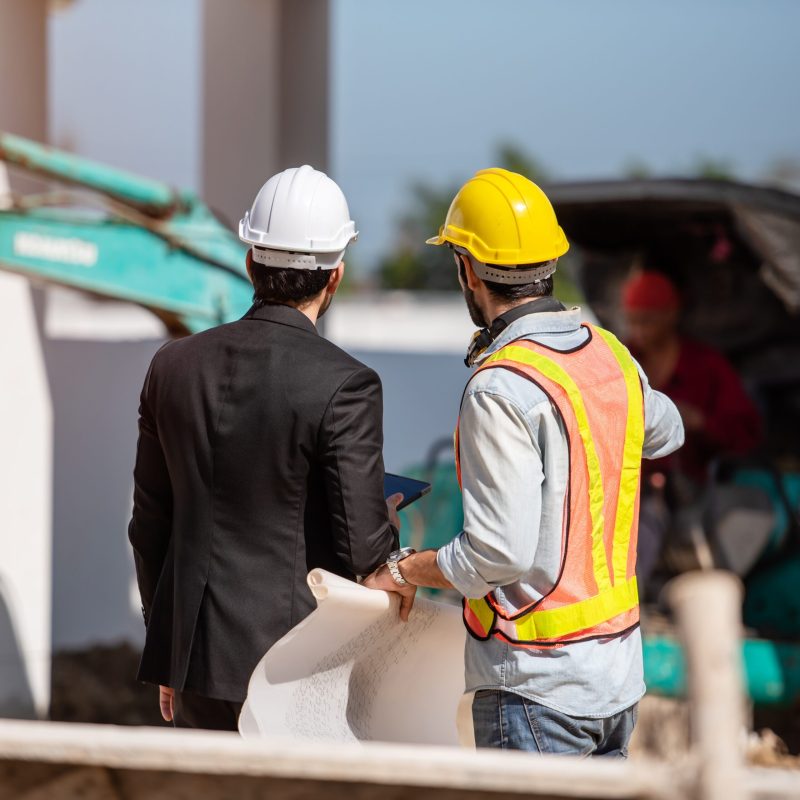 Construction worker and engineer working together on construction site.